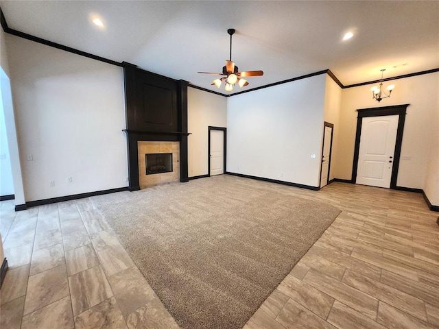 unfurnished living room featuring ceiling fan with notable chandelier, crown molding, and a tile fireplace