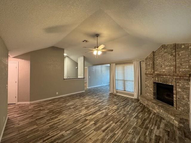 unfurnished living room with a fireplace, a textured ceiling, dark hardwood / wood-style flooring, and vaulted ceiling