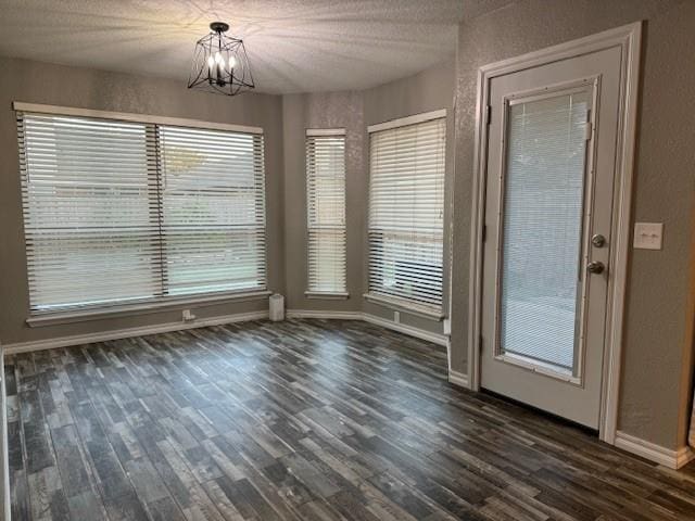 unfurnished dining area featuring dark hardwood / wood-style floors and a notable chandelier