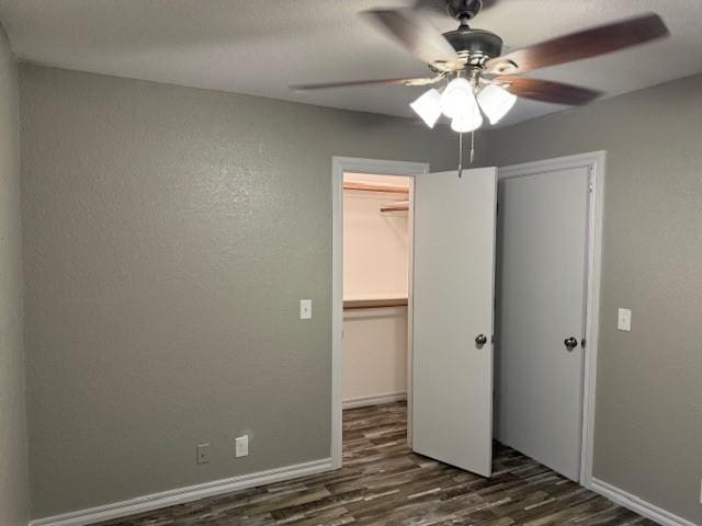 unfurnished bedroom with ceiling fan, a closet, and dark hardwood / wood-style floors