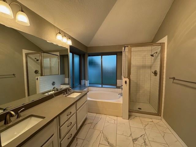 bathroom featuring a textured ceiling, vanity, vaulted ceiling, and shower with separate bathtub