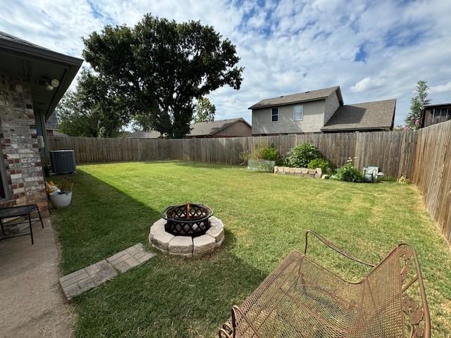 view of yard featuring cooling unit and an outdoor fire pit