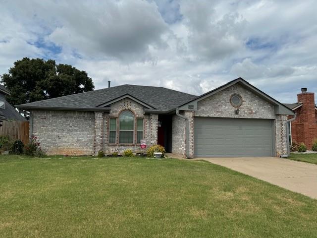 single story home with a garage and a front yard