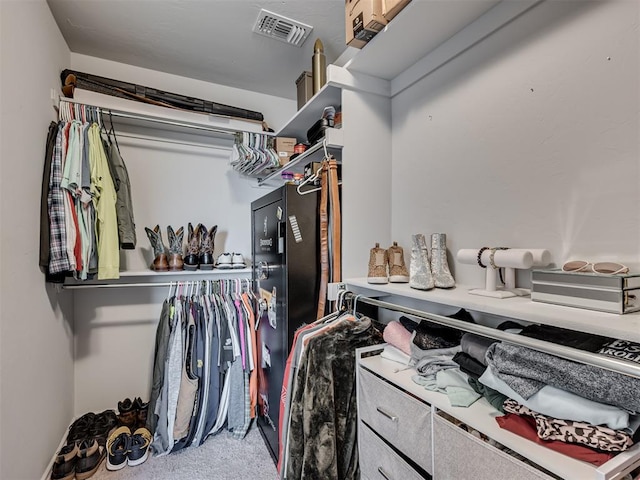 walk in closet featuring light carpet