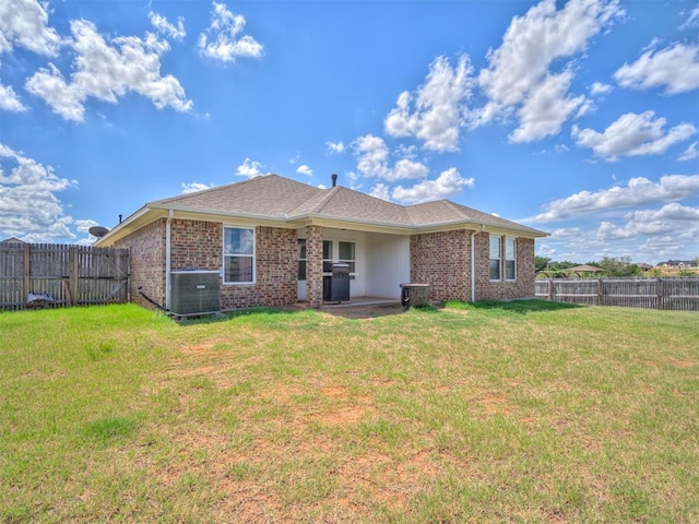 rear view of house featuring a yard and central AC unit