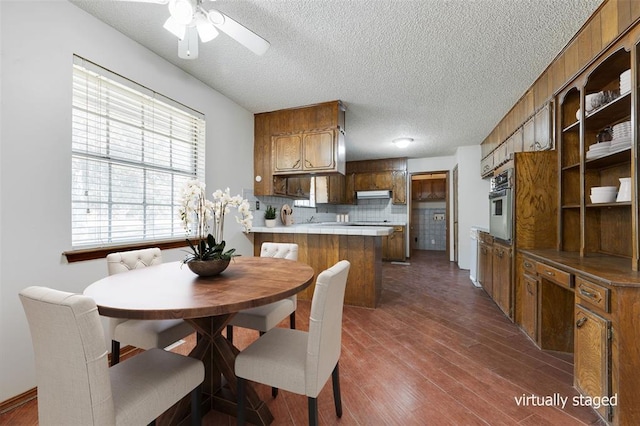 dining area featuring a textured ceiling, ceiling fan, and dark wood-type flooring