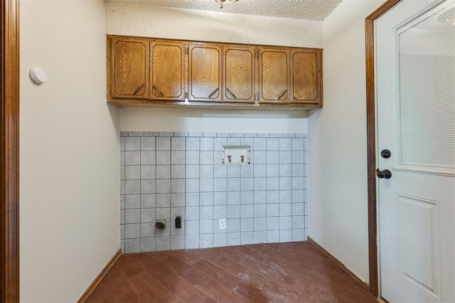 washroom featuring cabinets, washer hookup, dark hardwood / wood-style flooring, a textured ceiling, and tile walls