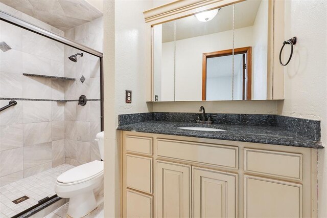 bathroom featuring a shower with door, vanity, and toilet