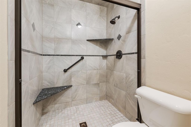 bathroom featuring tiled shower and toilet