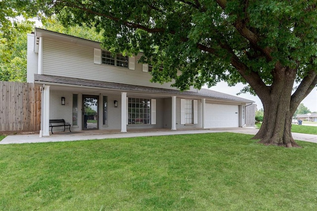 view of front of property with a front lawn, covered porch, and a garage