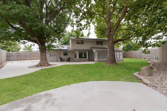 back of house featuring a lawn and a patio