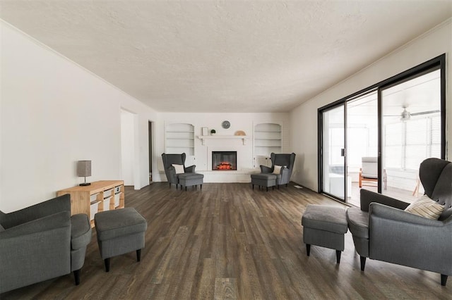 living room featuring wood-type flooring, a textured ceiling, and ceiling fan