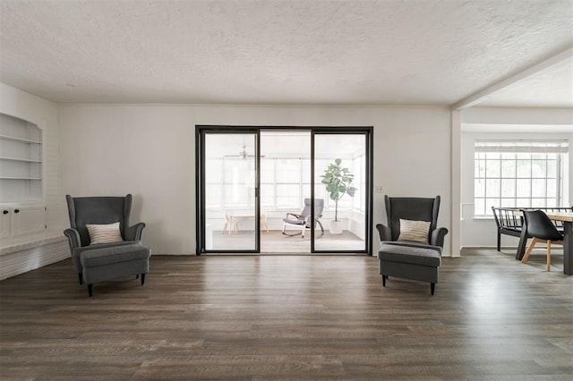 living area with dark hardwood / wood-style floors and a textured ceiling