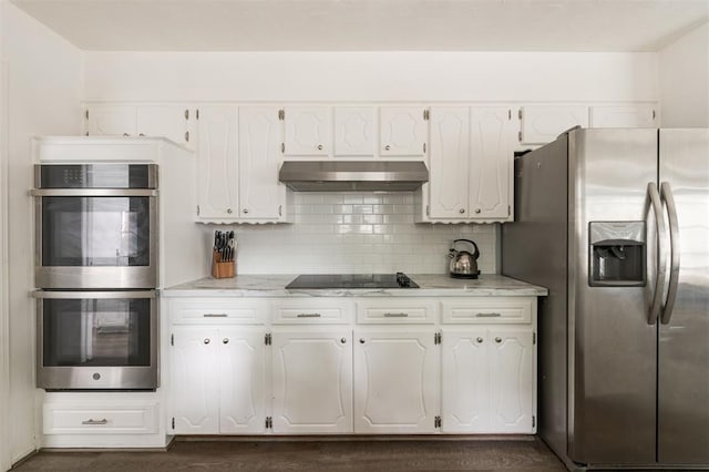 kitchen with dark hardwood / wood-style floors, light stone countertops, appliances with stainless steel finishes, tasteful backsplash, and white cabinetry