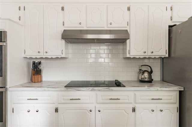 kitchen with backsplash, black electric cooktop, white cabinetry, and wall chimney range hood