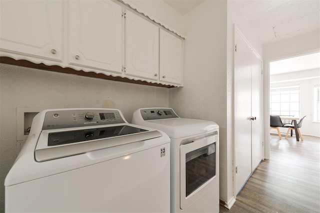 laundry area featuring light hardwood / wood-style floors, cabinets, and separate washer and dryer