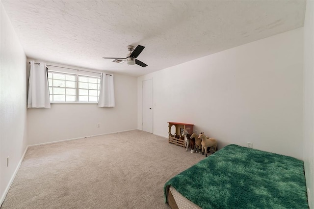 bedroom with carpet, ceiling fan, and a textured ceiling