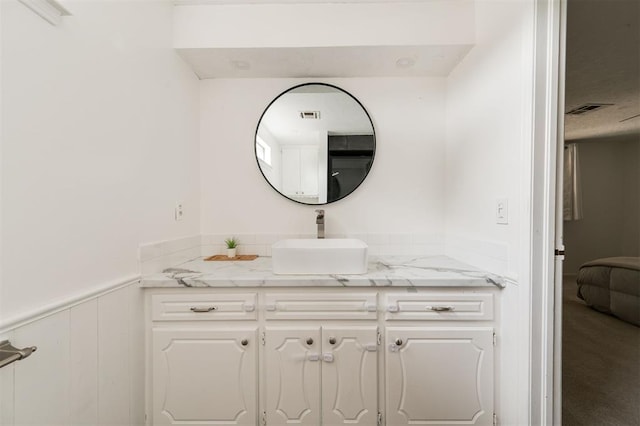 bathroom featuring vanity and wood walls