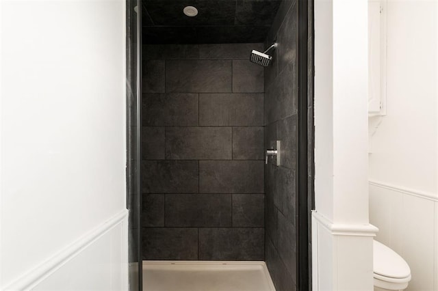 bathroom featuring toilet and tiled shower