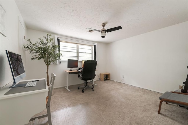 carpeted office featuring ceiling fan and a textured ceiling