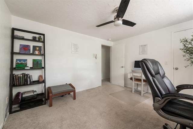 carpeted office space with ceiling fan and a textured ceiling