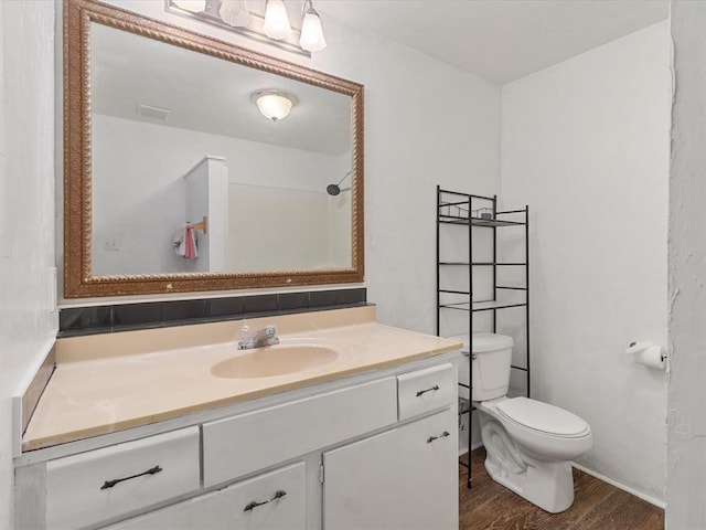 bathroom with vanity, wood-type flooring, and toilet