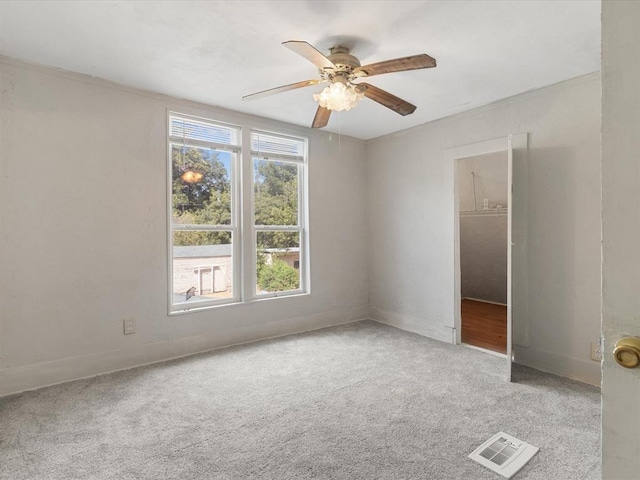 carpeted spare room featuring ceiling fan