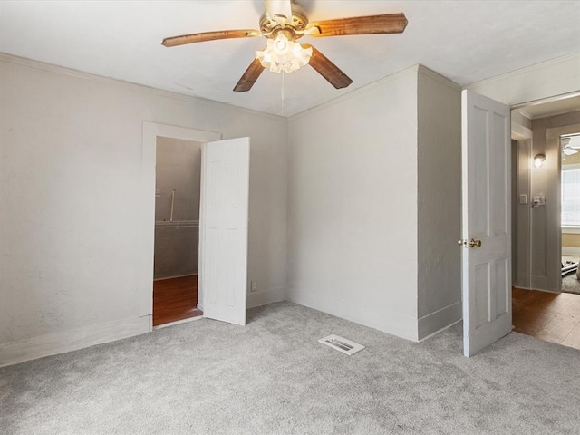 unfurnished bedroom featuring a closet, light colored carpet, ceiling fan, and ornamental molding