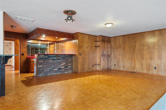 interior space featuring light parquet floors and wood walls