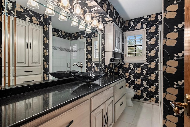 bathroom featuring vanity, a shower with door, tile patterned floors, and toilet