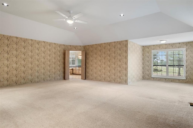 carpeted empty room featuring ceiling fan and lofted ceiling