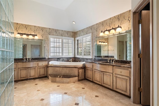 bathroom with tiled tub and vanity