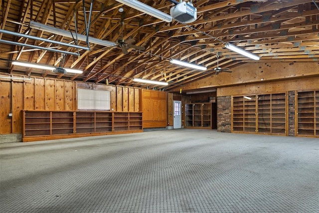 garage with a garage door opener and wood walls