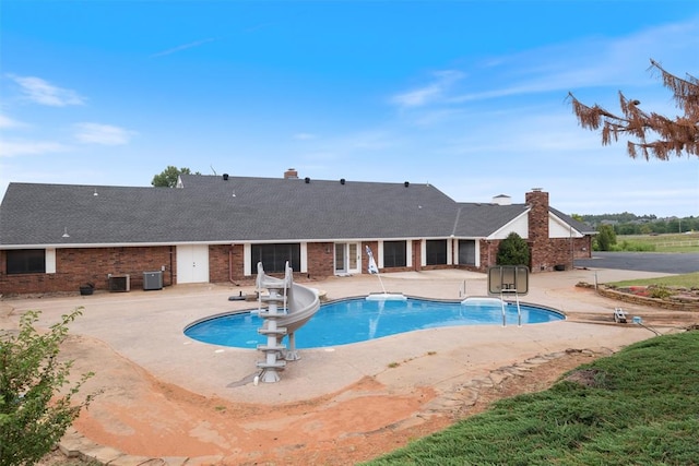 view of pool featuring a patio, a water slide, and central AC