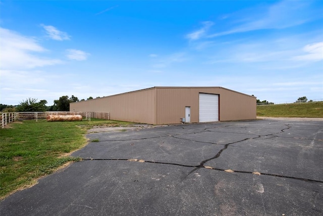 view of outbuilding featuring a garage and a lawn