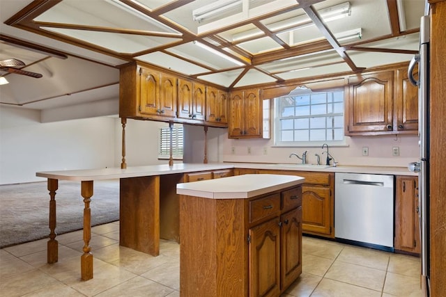 kitchen with a kitchen island, a healthy amount of sunlight, stainless steel dishwasher, and kitchen peninsula