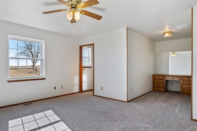 spare room featuring ceiling fan, carpet, and a wealth of natural light