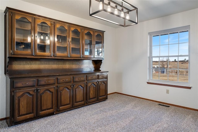 bar with light carpet and dark brown cabinets