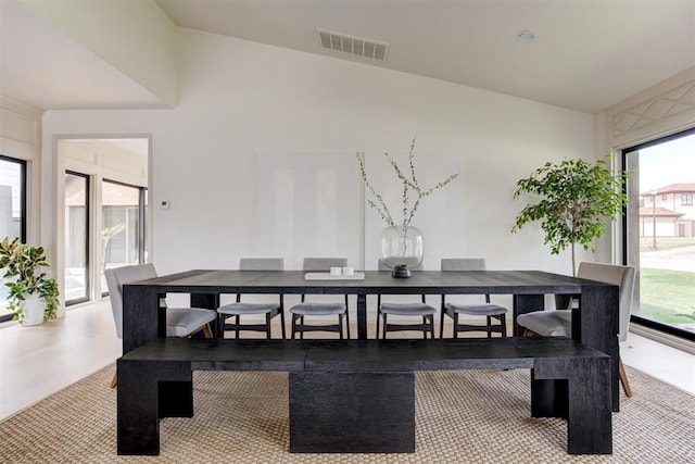 dining space featuring visible vents, high vaulted ceiling, and wood finished floors