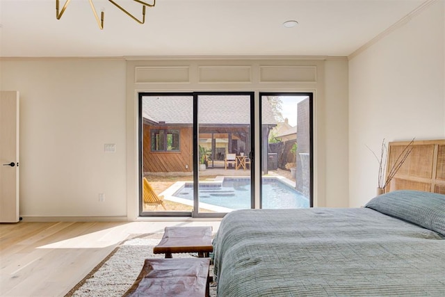 bedroom with crown molding, baseboards, a chandelier, wood finished floors, and access to outside