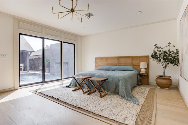 bedroom featuring light wood-style flooring, baseboards, an inviting chandelier, and access to exterior