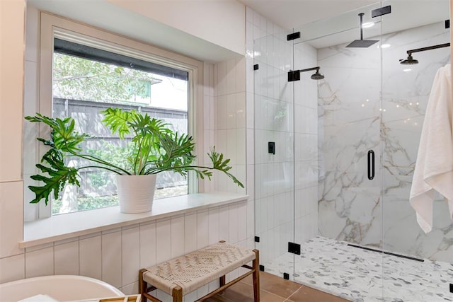 bathroom featuring a marble finish shower, a soaking tub, and tile patterned flooring