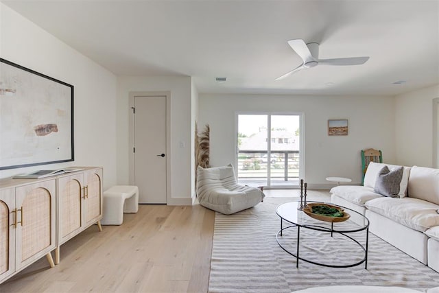 living area with a ceiling fan, visible vents, light wood-type flooring, and baseboards