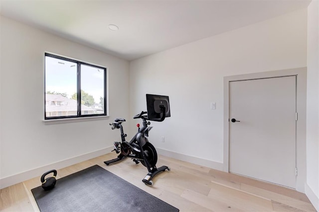 workout area featuring light wood-style flooring and baseboards