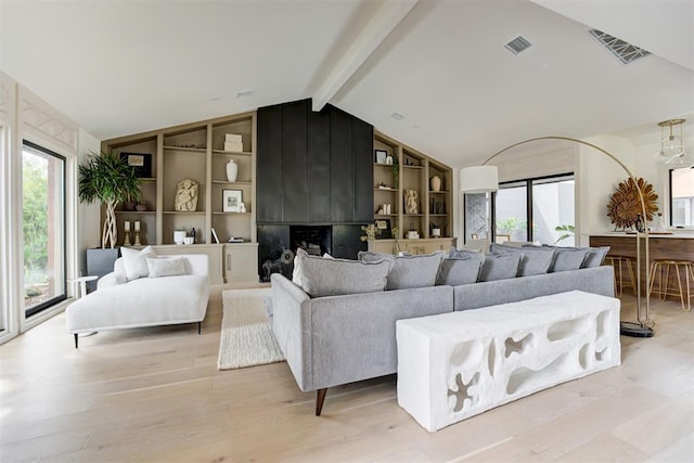 living room featuring visible vents, a healthy amount of sunlight, and light wood-type flooring