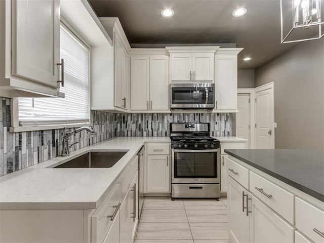 kitchen with white cabinets, sink, light tile patterned floors, and stainless steel appliances