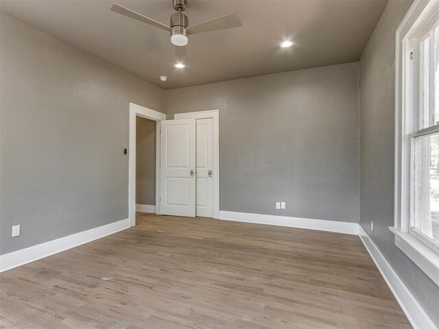 empty room with ceiling fan and light hardwood / wood-style flooring