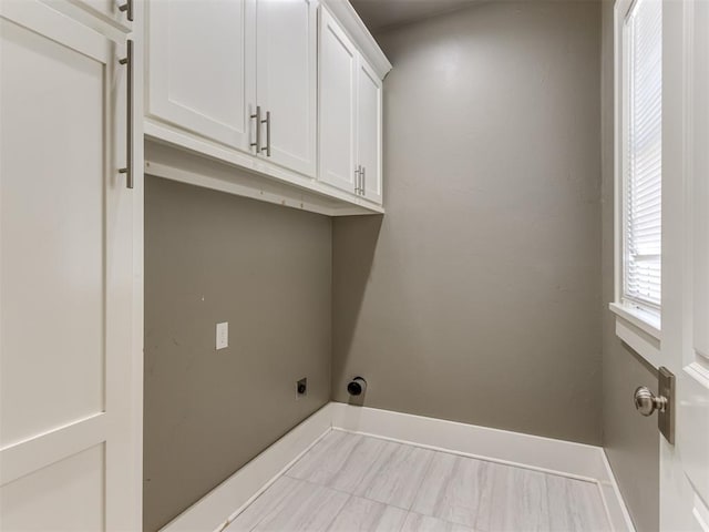 clothes washing area featuring hookup for an electric dryer and cabinets