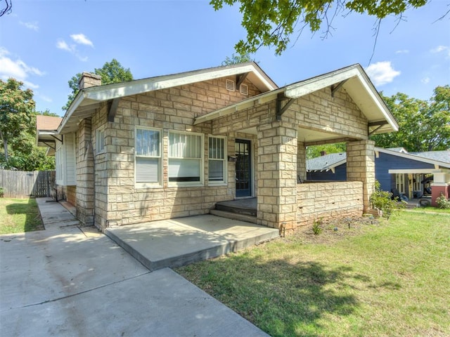 view of front of house featuring a patio area and a front lawn