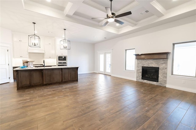 kitchen featuring dark hardwood / wood-style flooring, white cabinetry, coffered ceiling, and a center island with sink